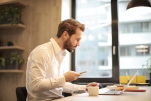 Man in a white dress shirt, looking intently into the distance, representing the focused and strategic nature of the business prospecting meaning.